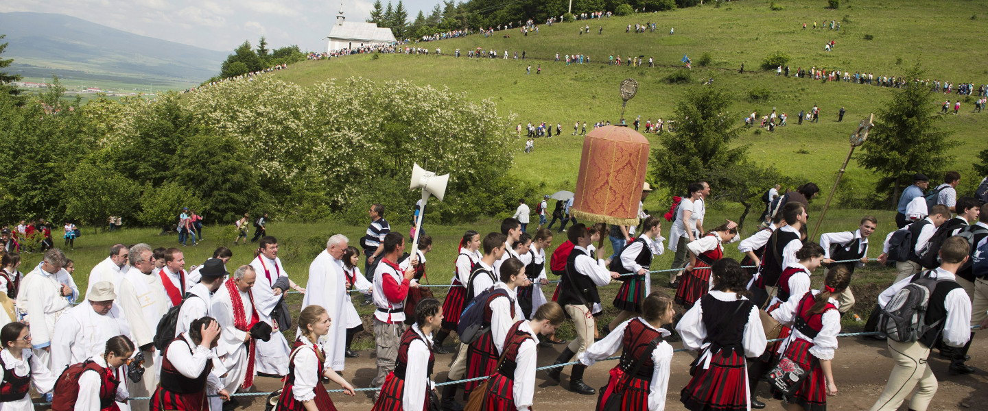 A labarumot viszik a csíksomlyói kegytemplomból a csíksomlyói búcsún tartott szentmisére, a Kis- és Nagysomlyó-hegy közötti hegynyereghez 2014.június 7-én